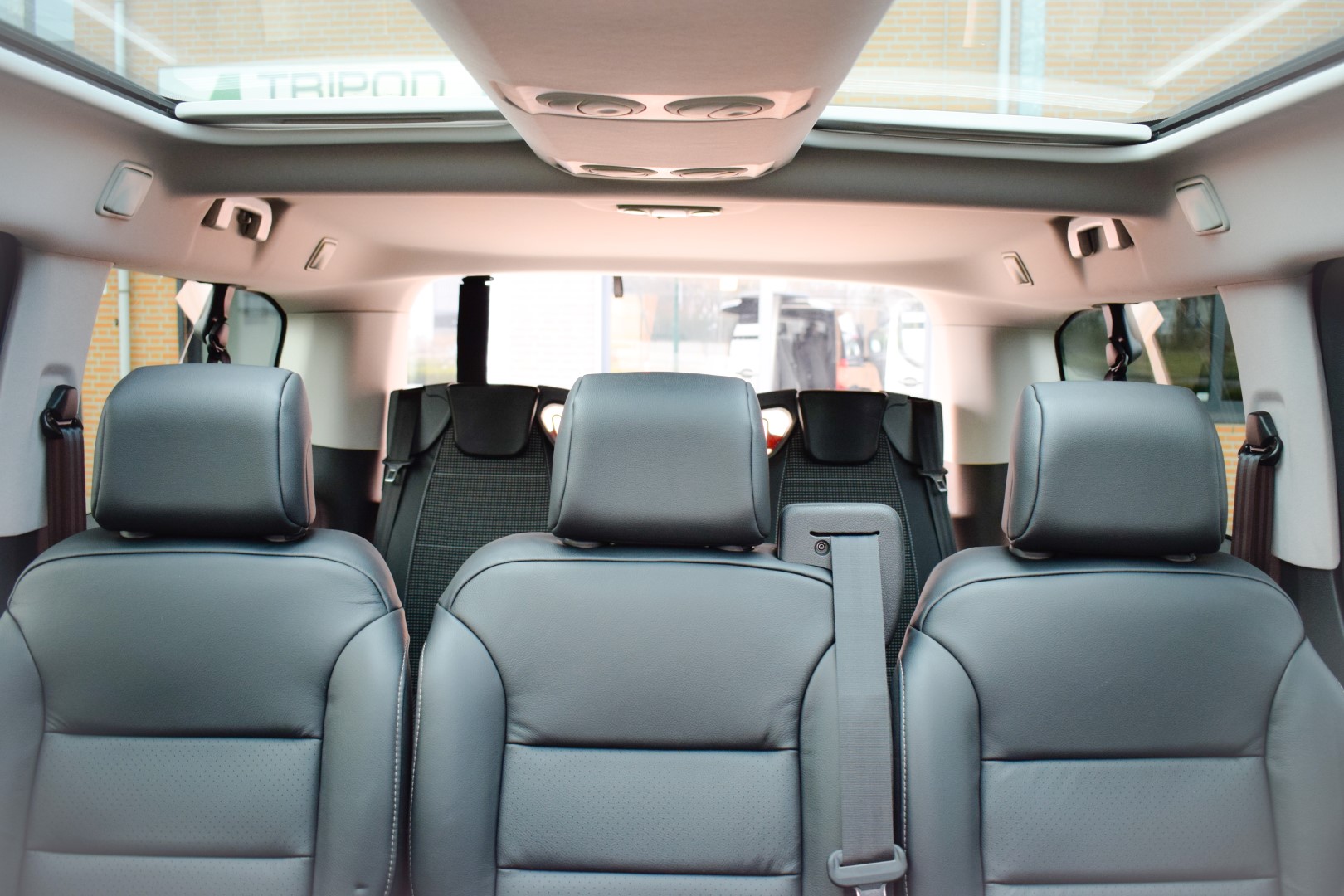 Citroen-Jumpy-TPMR Intérieur d'une voiture avec sièges en cuir noir et toit panoramique.