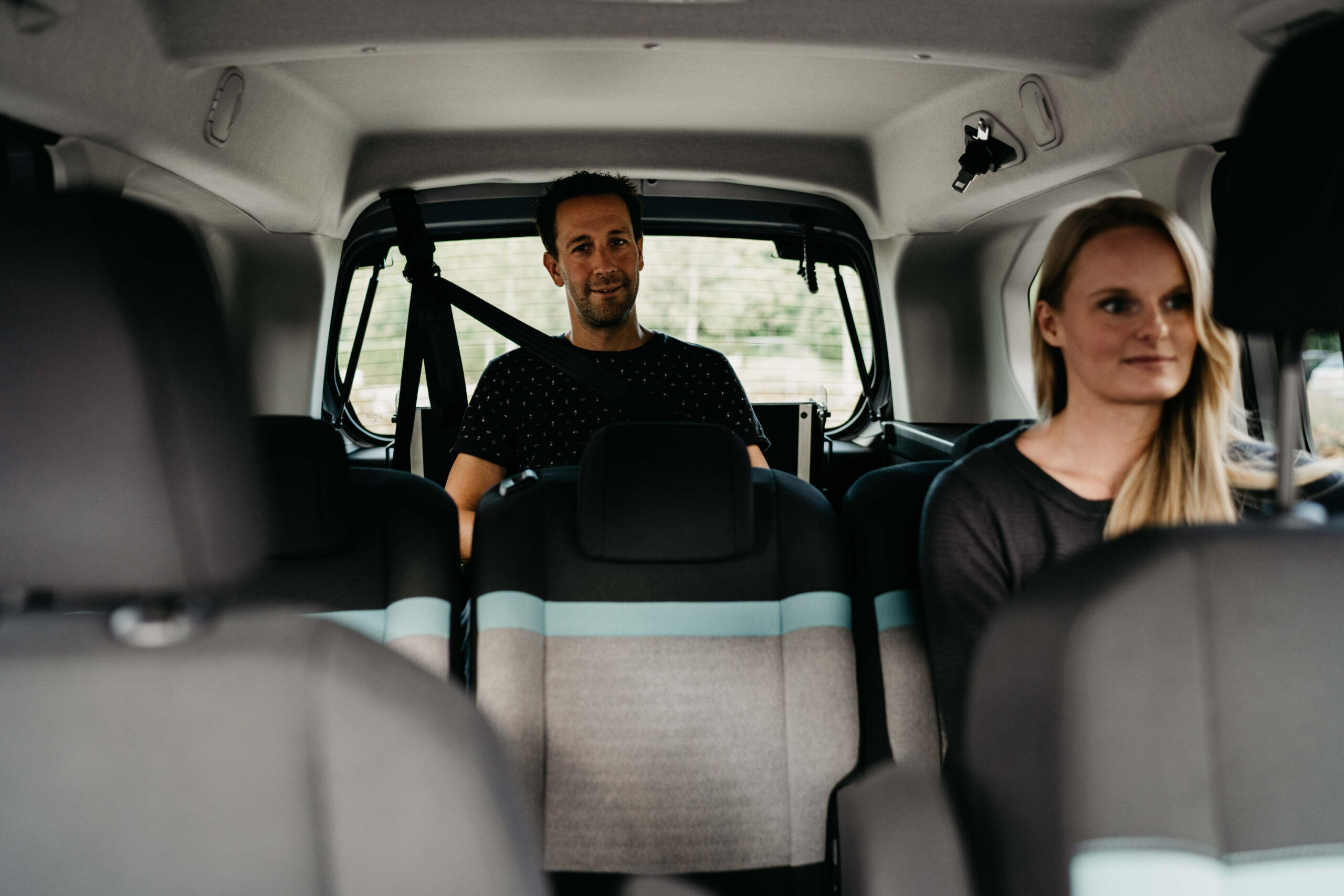 Passagers Homme Femme Van Sieges Arriere Deux passagers dans un van, un homme et une femme, regardant vers l'avant depuis les sièges arrière.