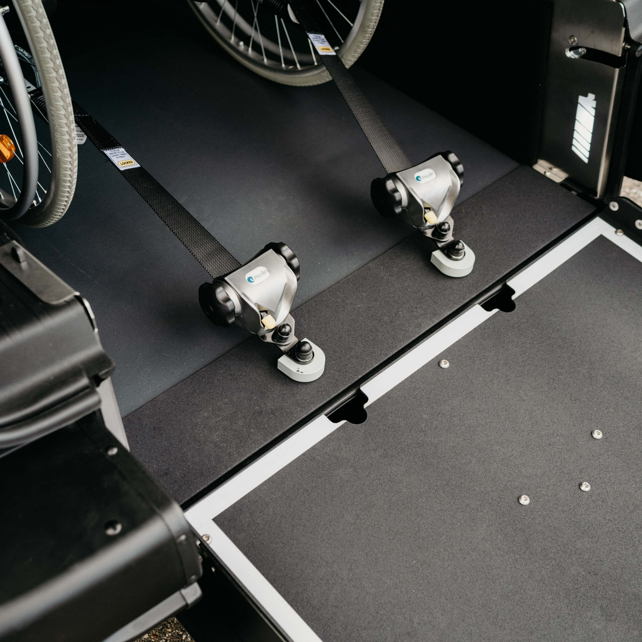 Systeme Arrimage Fauteuil Roulant Sangles Système d'arrimage pour fauteuil roulant avec sangles et fixations sécurisées. Mobilité et accessibilité.