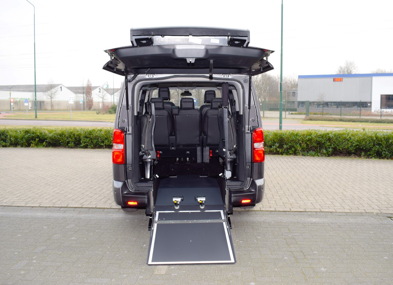 Citroen-Jumpy-TPMR monospace aménagé gris avec rampe d'accès pour fauteuil roulant ouverte à l'arrière.